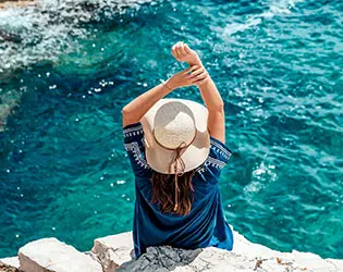 Turista en la playa con agua turquesa